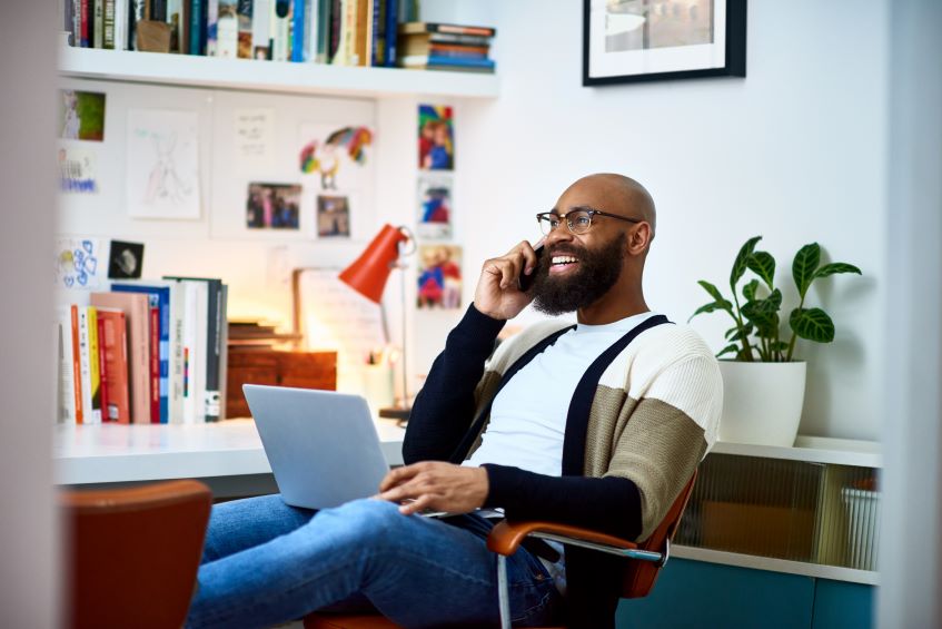 Man on talking on his phone, with laptop in office