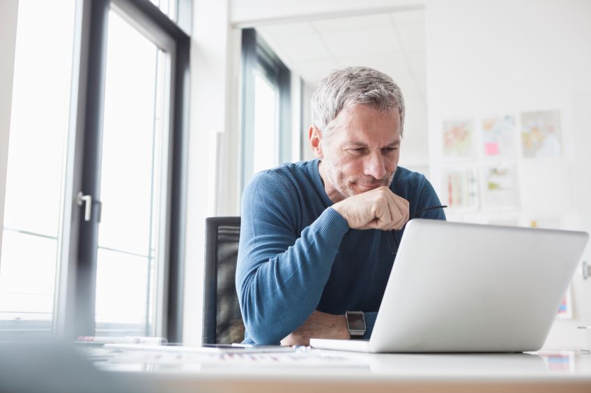 man at laptop looking concerned