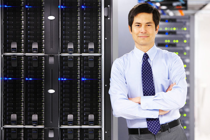 businessman leans confidently on servers