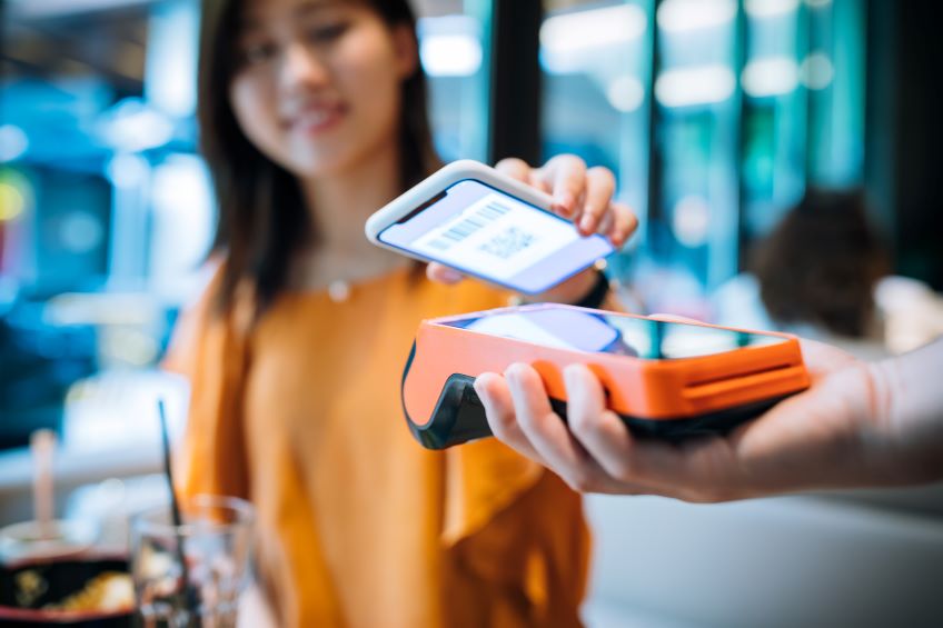 Close up of woman holding her phone to scan for a purchase