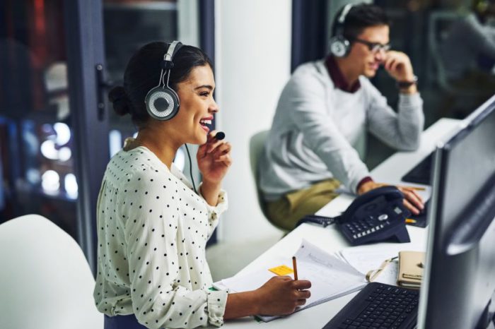 Woman at call center smiles while on her headset.