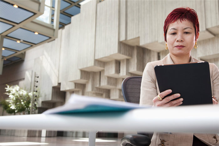 Businesswoman using the network in her office to connect to her tablet