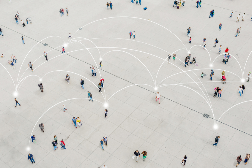 Overhead image of people walking in a plaza with network lines connecting them