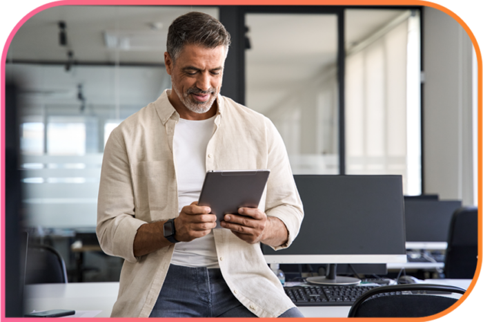 Person in an office holding and looking at a tablet.