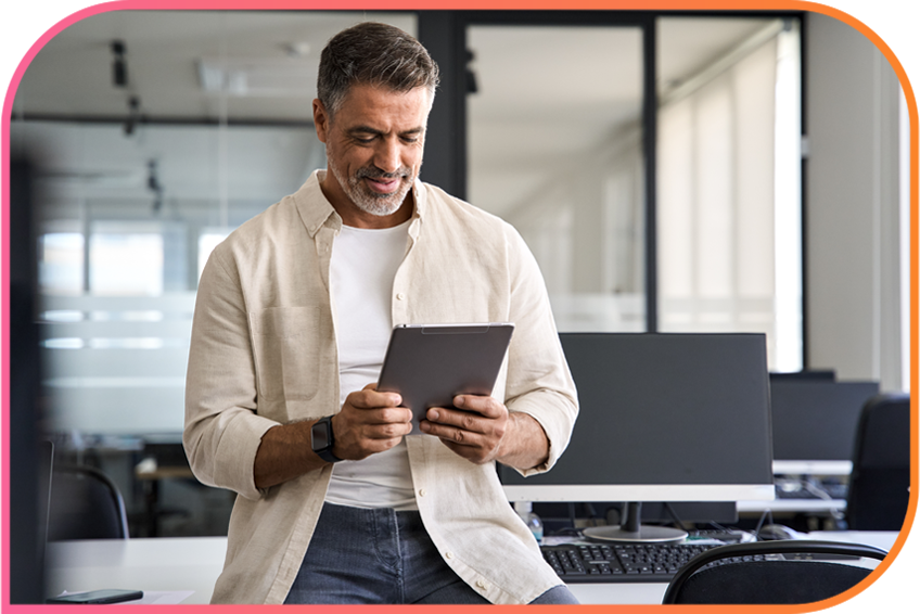 Person in an office holding and looking at a tablet.