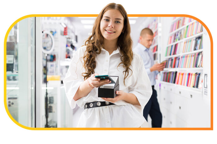 Young woman smiling into camera being pleased after making a transaction on the smart phone in her hand.