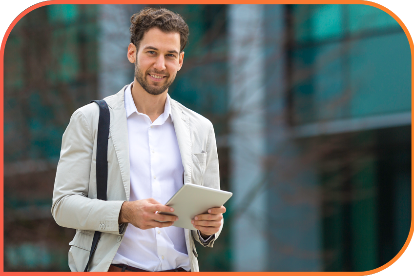 The image depicts a person standing outside using a tablet. They are dressed in casual business attire, including a white shirt and grey jacket and are set against a blurred background that suggests an urban setting.